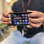 Person with their fingers on a braille touch keyboard on their mobile phone.